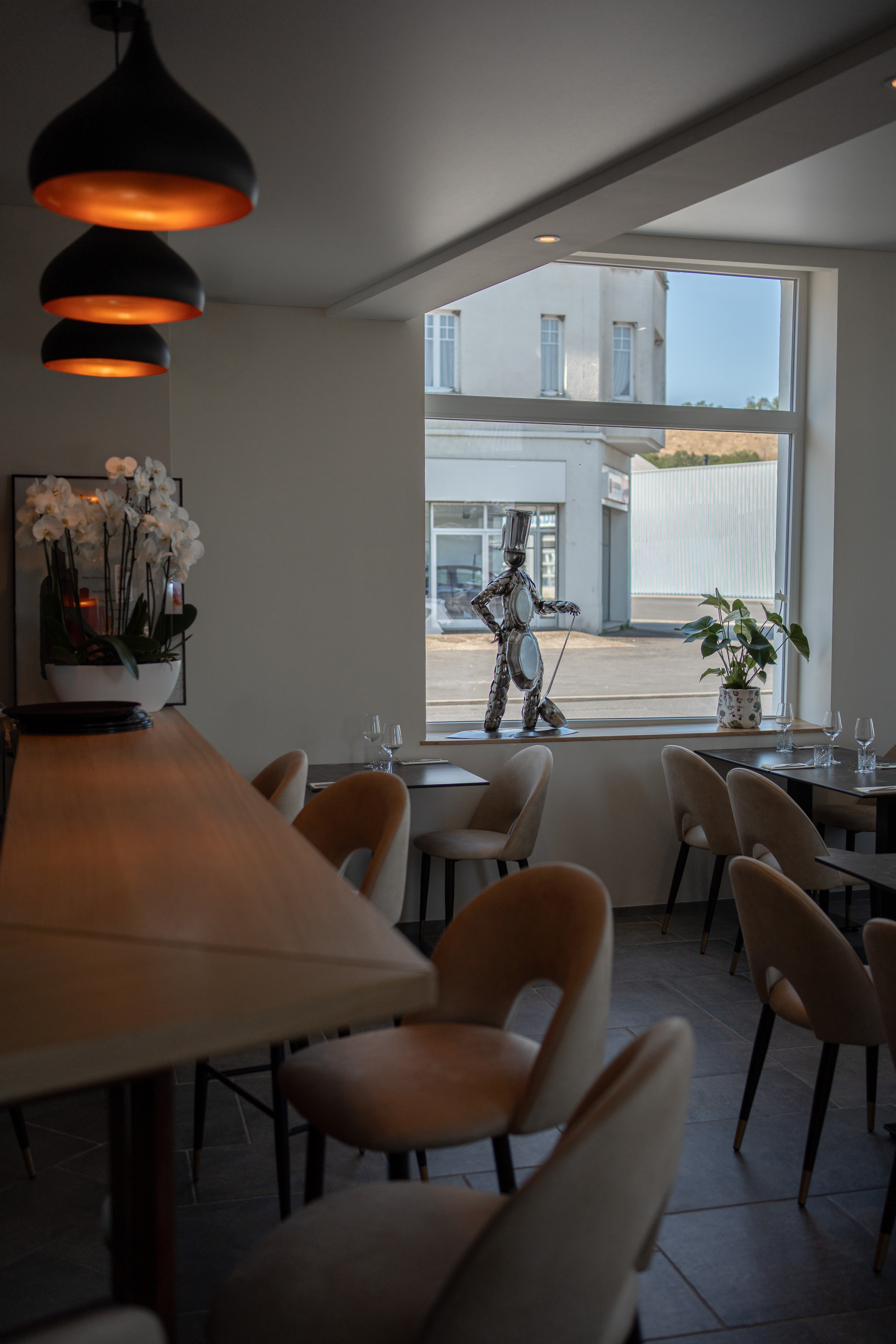 Vue du bar avec comptoir, grande fen&ecirc;tre et sculpture m&eacute;tallique