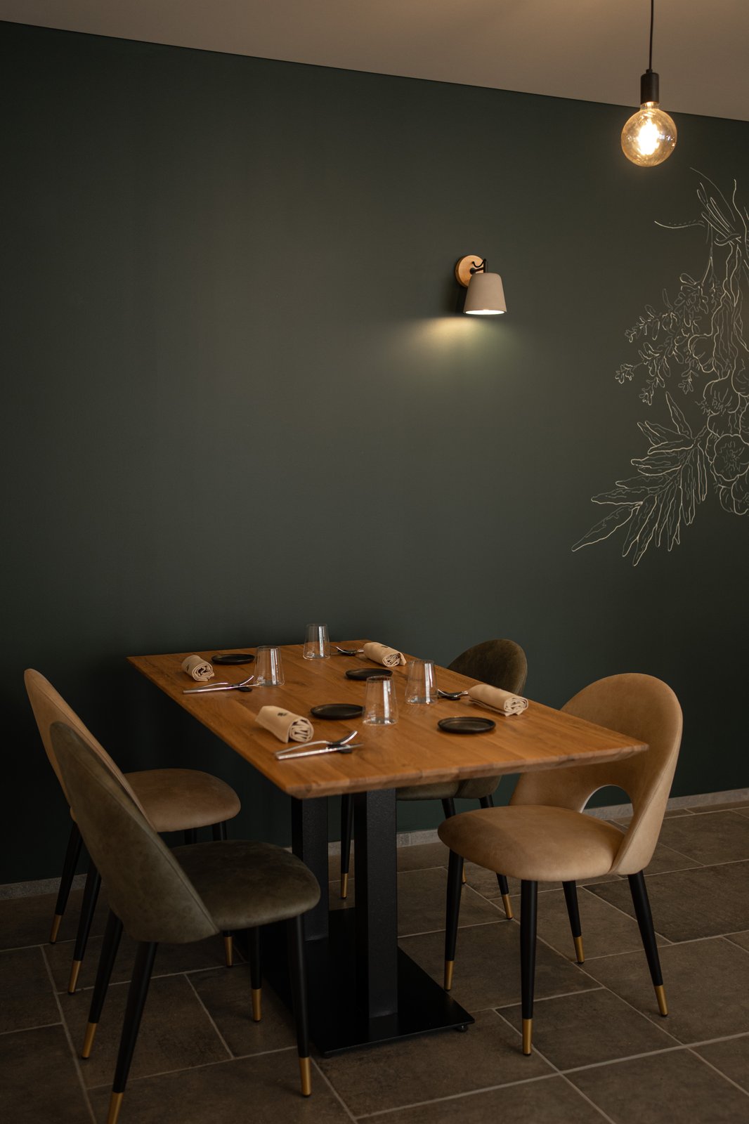 Table dress&eacute;e devant le mur vert et fresque botanique