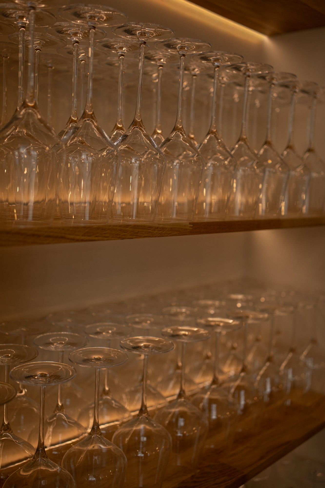 Verres align&eacute;s sur &eacute;tag&egrave;re en bois r&eacute;tro-&eacute;clair&eacute;e